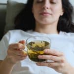 femme allongee sur un canapé tenant une tisane