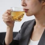Femme assise buvant une tisane au gingembre