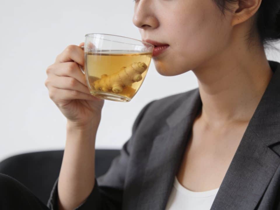 Femme assise buvant une tisane au gingembre