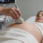 femme allongee sur table medicale subissant echographie