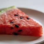 Tranche de pasteque rouge sur assiette blanche
